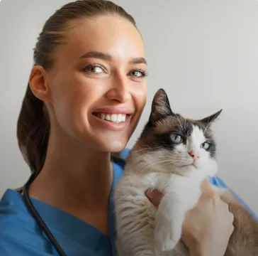Veterinária segurando um gato no colo